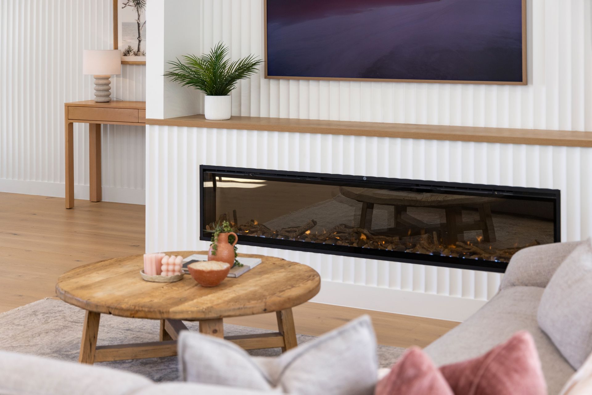 A living room with a fireplace , couch , coffee table and television.