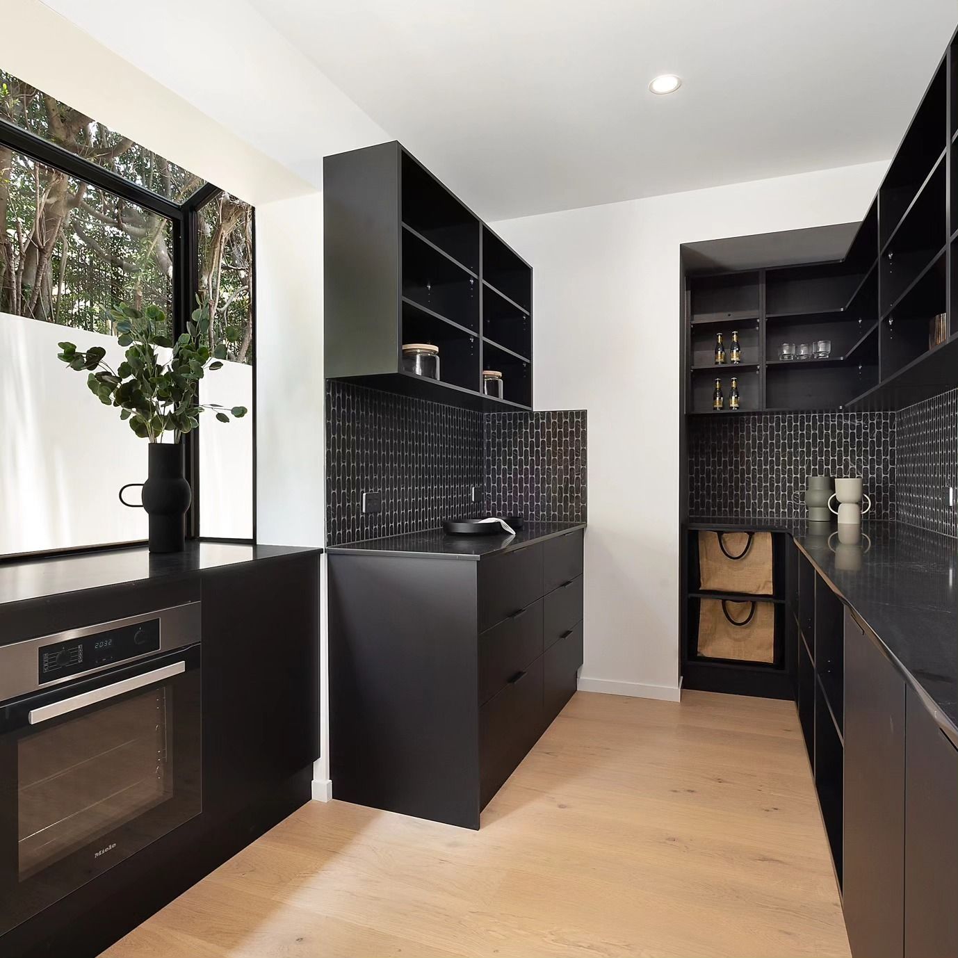 A kitchen with black cabinets and stainless steel appliances