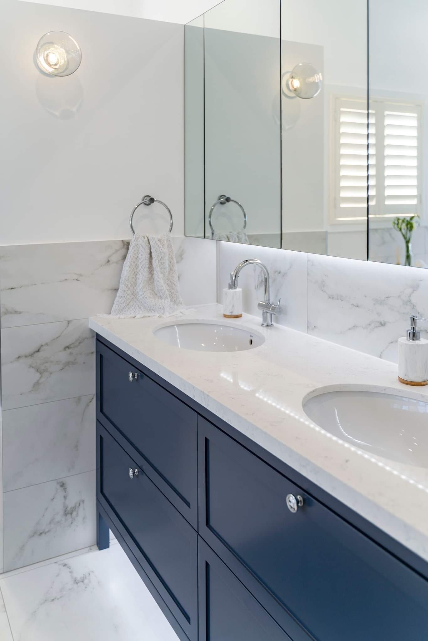 A bathroom with two sinks and a large mirror.