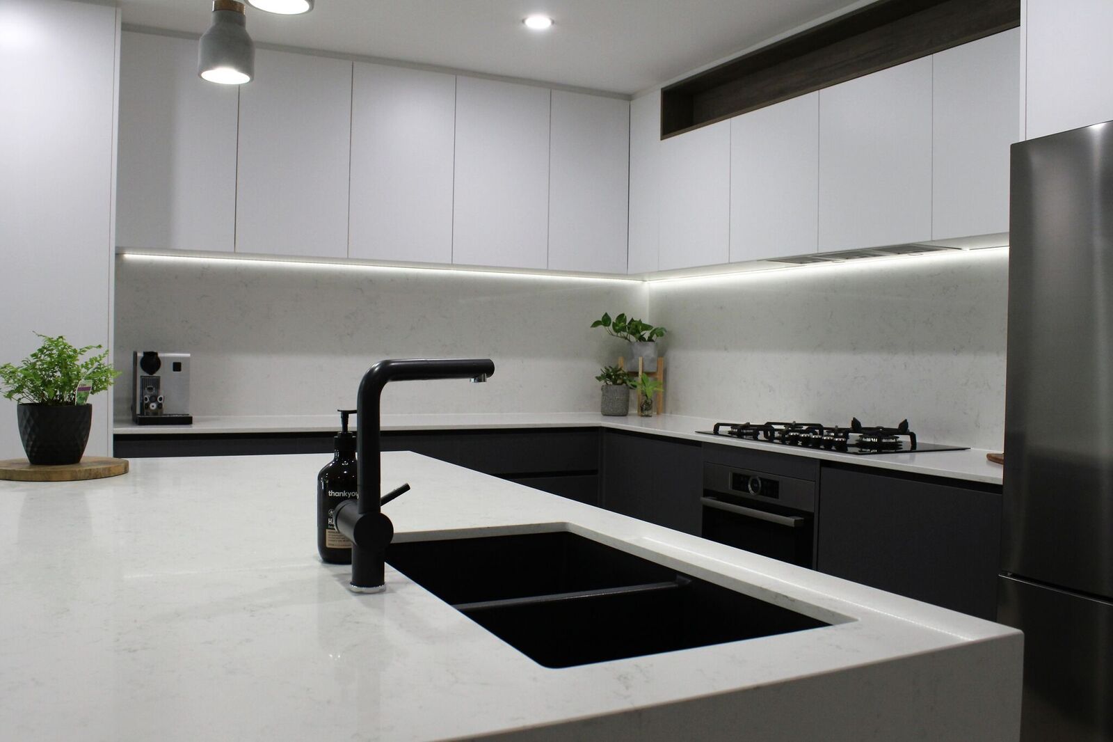 A Kitchen With White Cabinets, Stone Benchtop And Black Matte Tapware— Tailored Interiors in Wacol, QLD