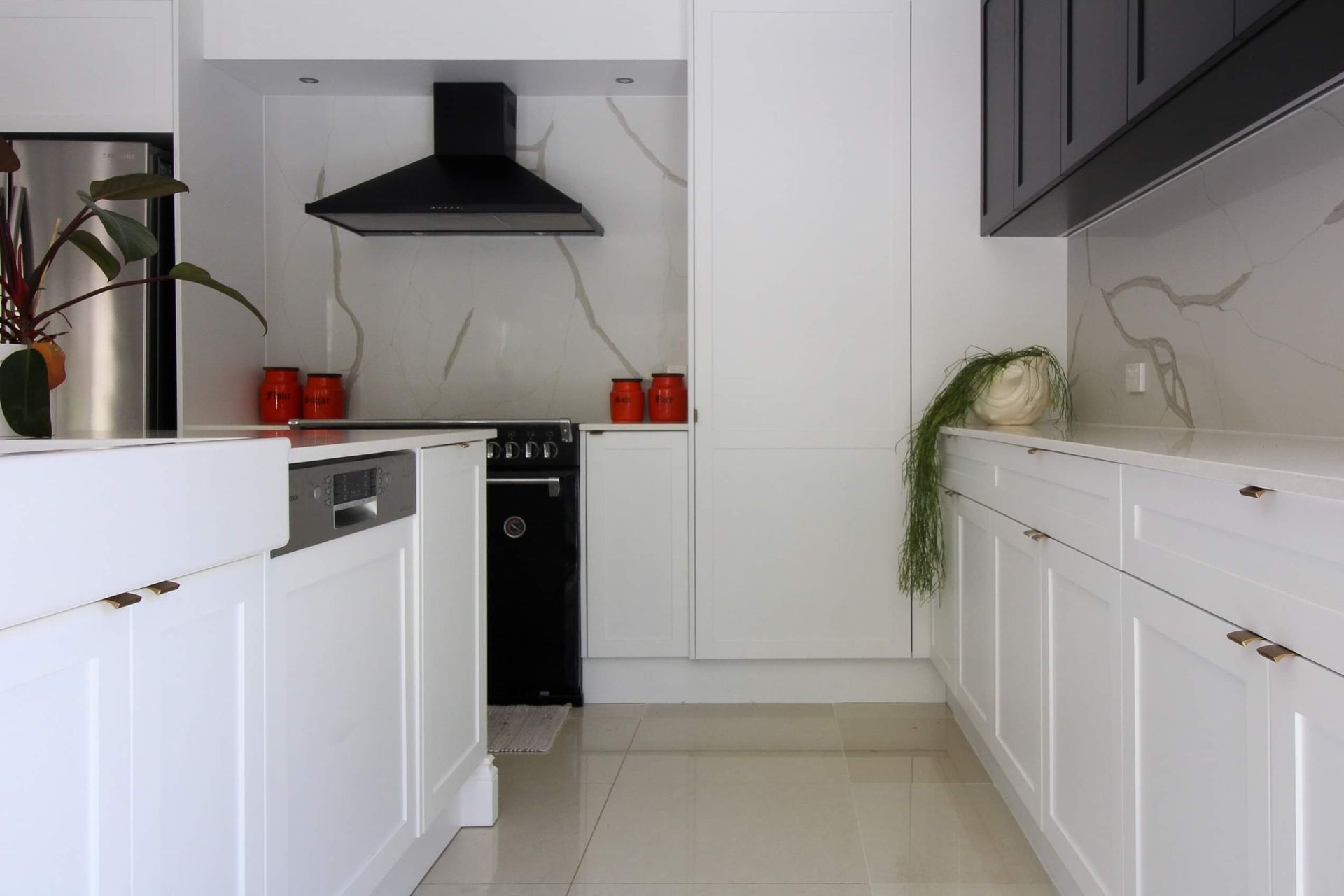A kitchen with white cabinets and a black stove top oven
