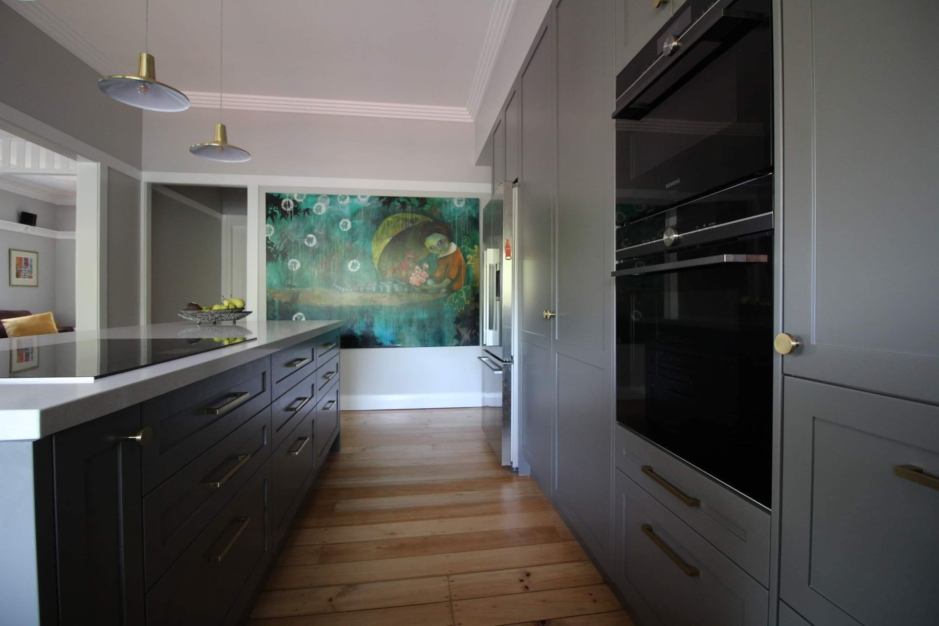 A kitchen with a large painting on the wall and a large island.