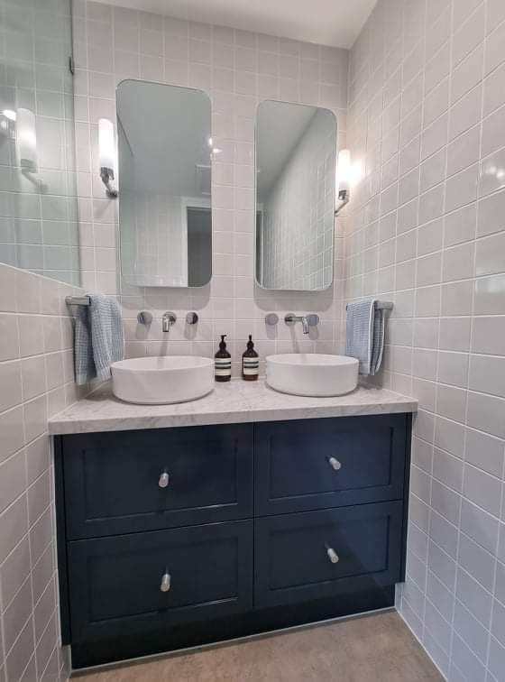 A bathroom with two sinks and two mirrors.