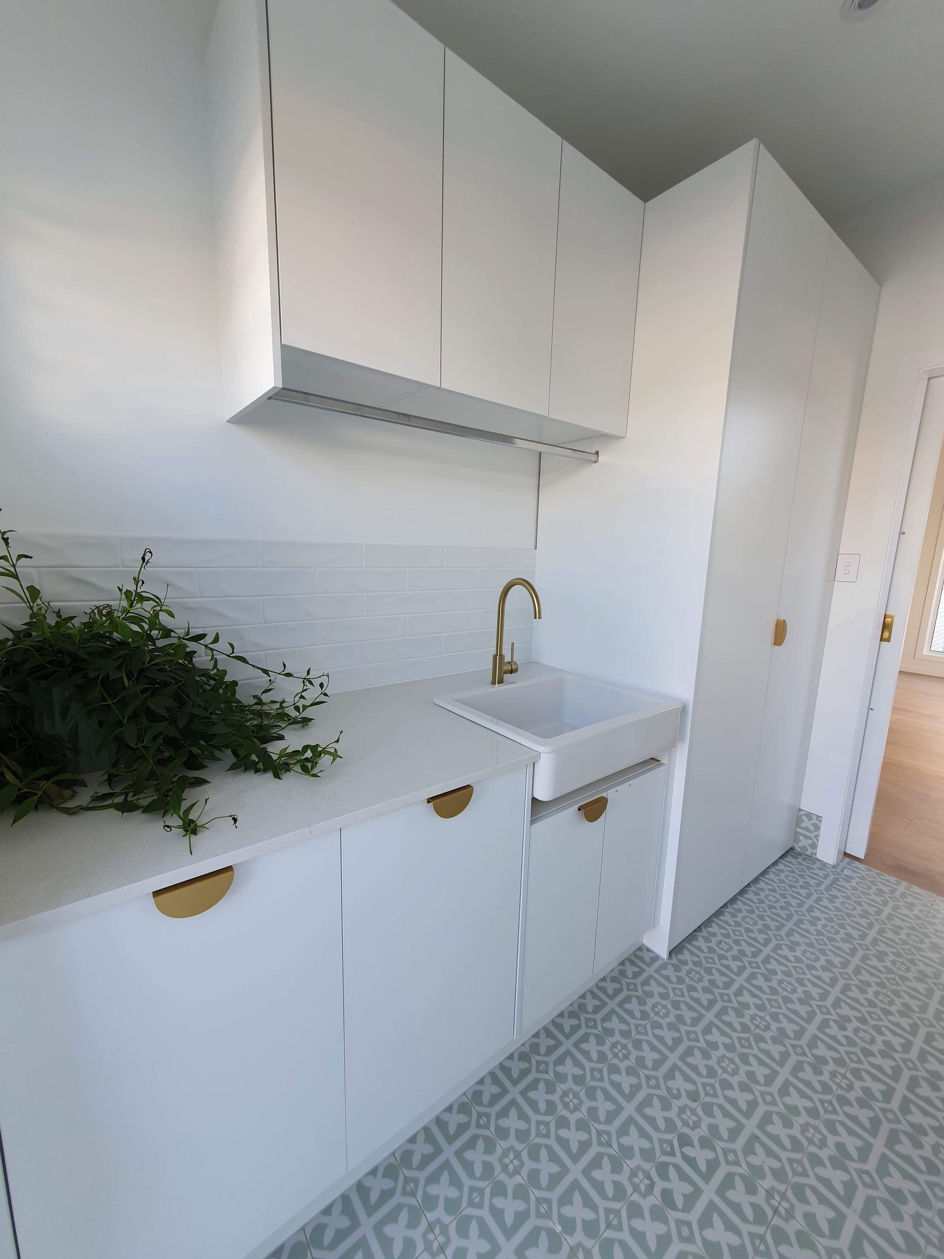 A kitchen with white cabinets and a sink.