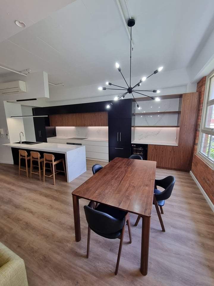 There is a table and chairs in the middle of the room.