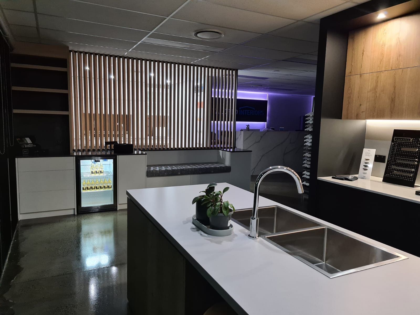 A kitchen with a stainless steel sink and a refrigerator.