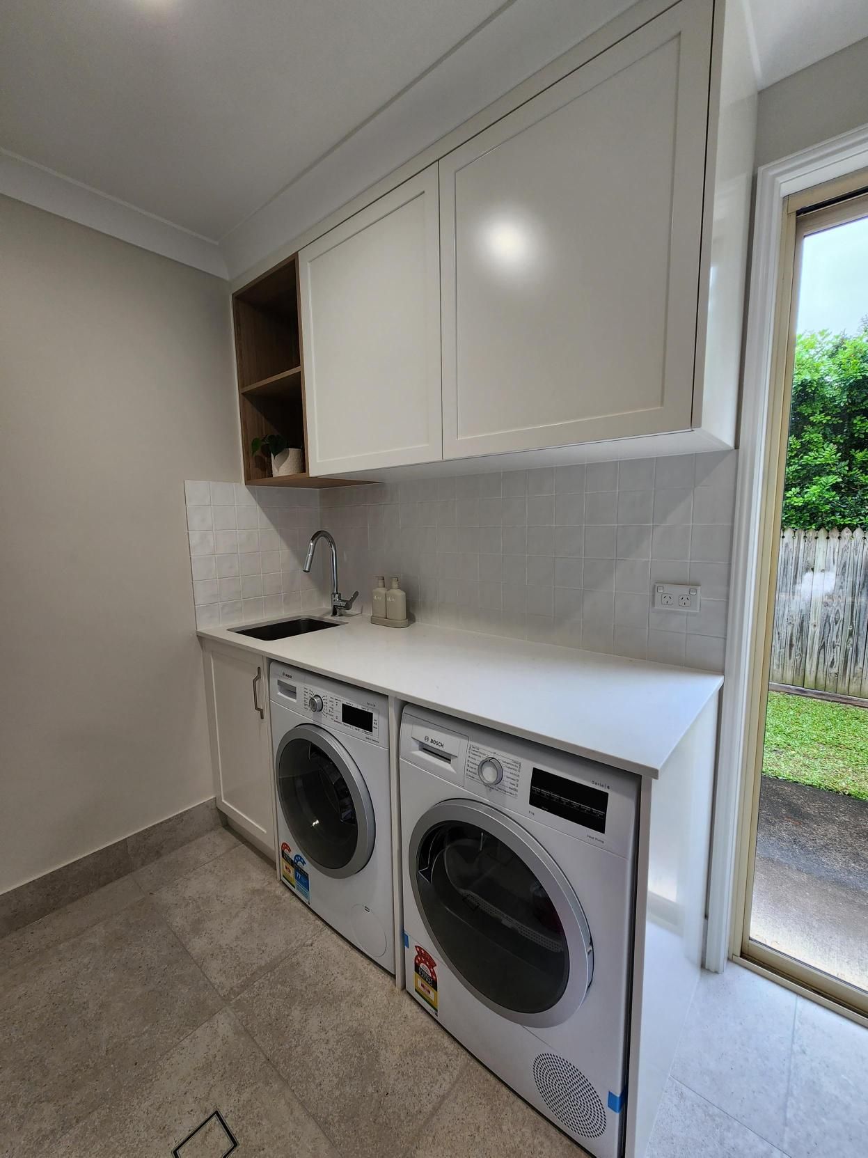 A Laundry Room with A Washer and Dryer Stacked on Top of Each Other — Tailored Interiors in Wacol, QLD