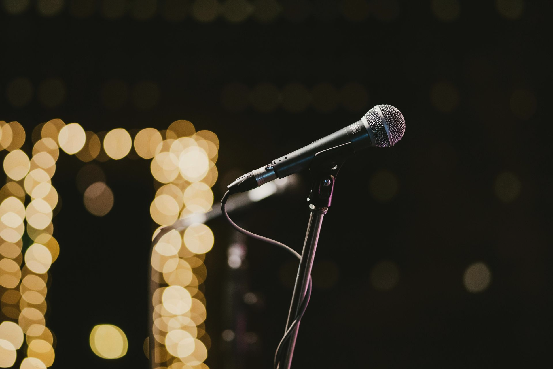 Microphone with bokeh lights in the background, promoting la dragon live music kilmarnock