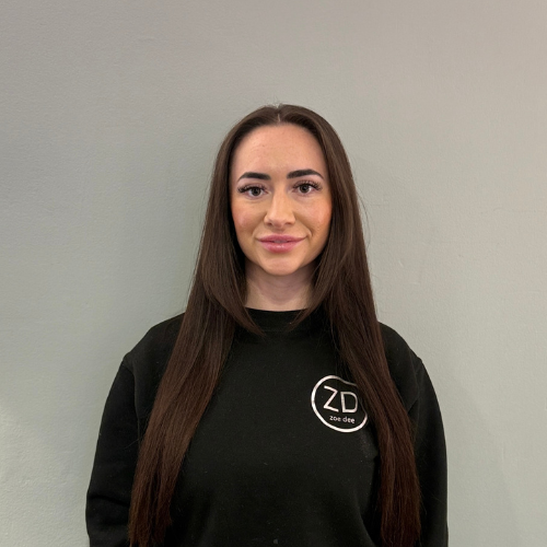 Charlotte with long brown hair is wearing a black Zoe Dee logo sweatshirt.