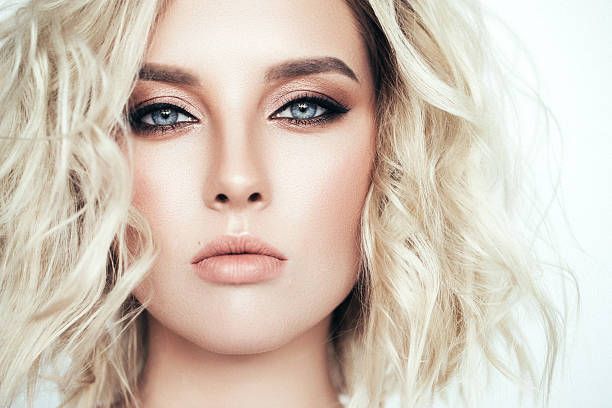 A close up of a woman 's face with blonde hair.