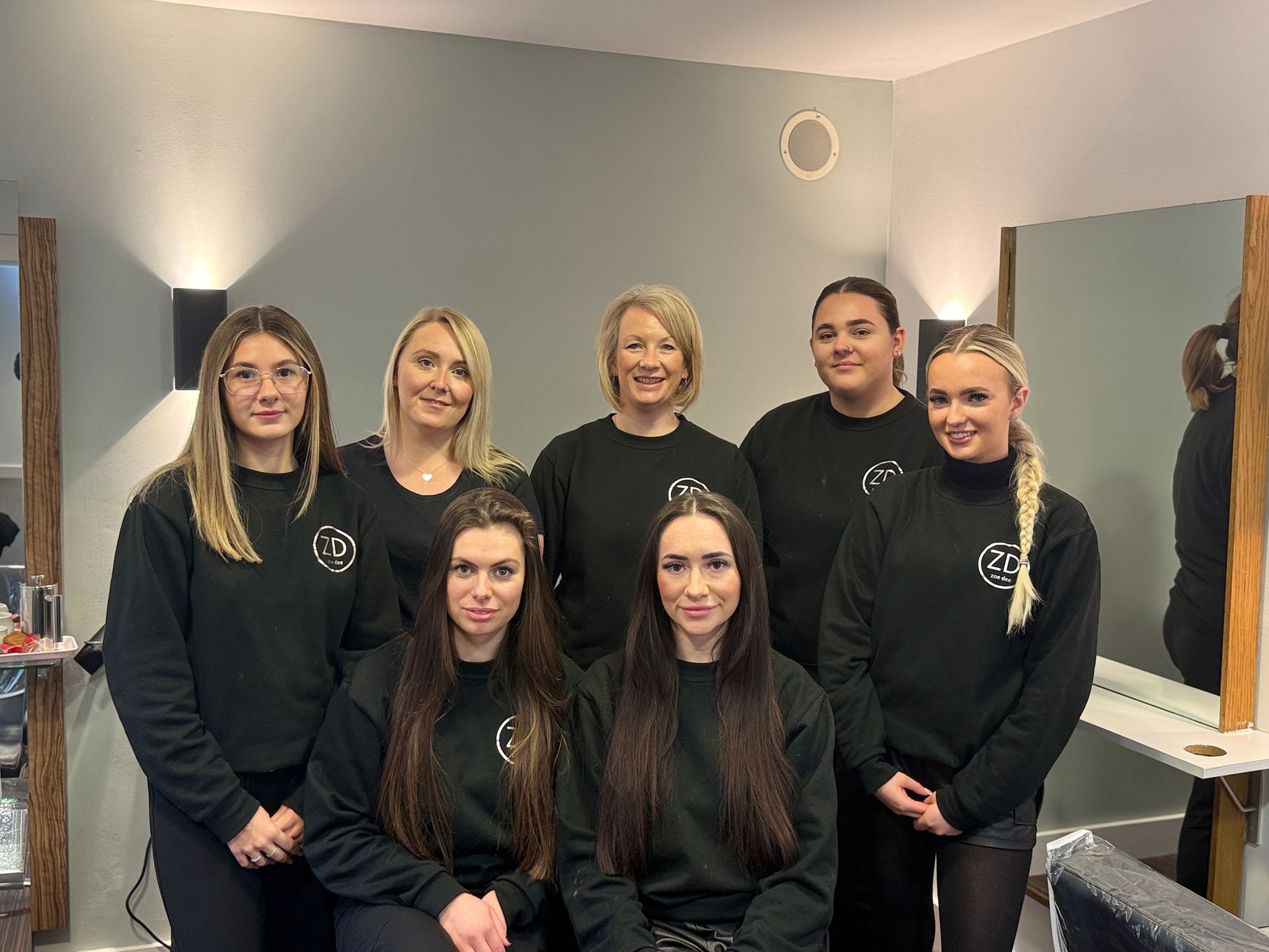 The team at Zoe Dee are posing for a picture in a salon.