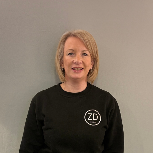 Zoe Hobday is wearing a black sweatshirt with a Zoe Dee logo on the front.