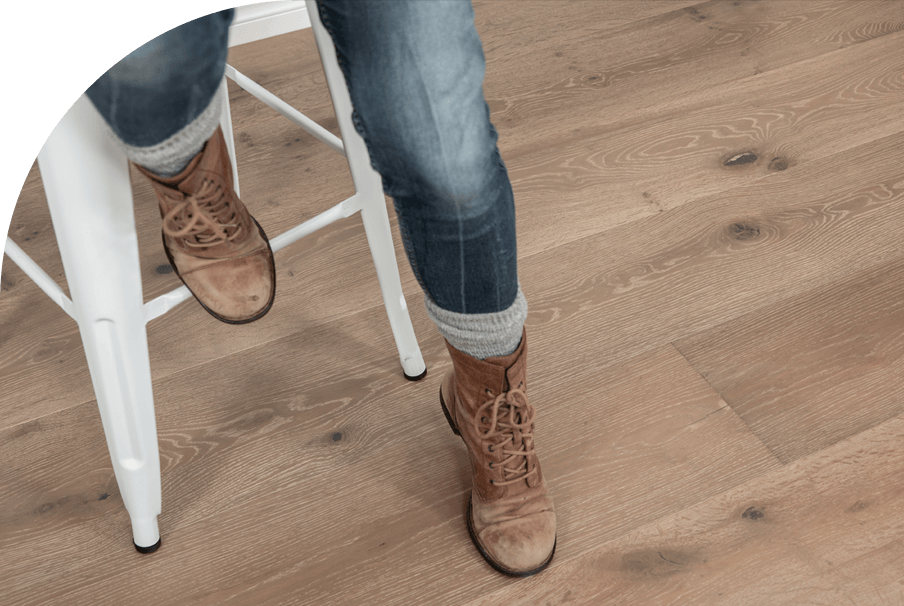 A homeowner wearing brown boots stepping on premium hardwood floors