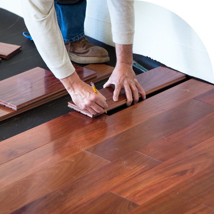 A professional installing hardwood floor planks