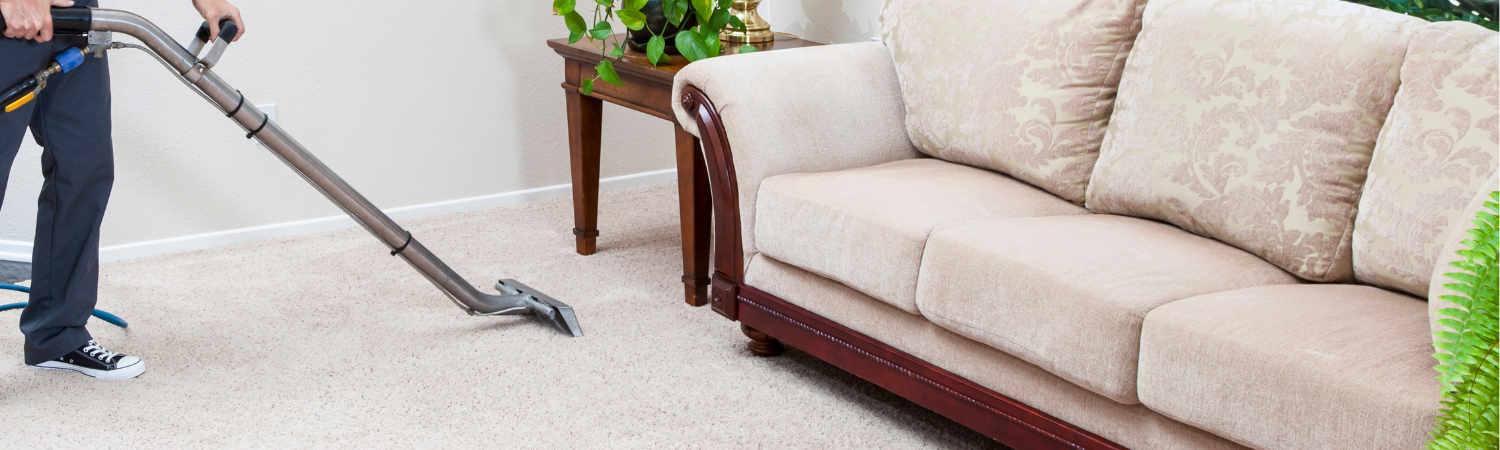 A carpeted bedroom with a bed , chair , nightstand , and bench.