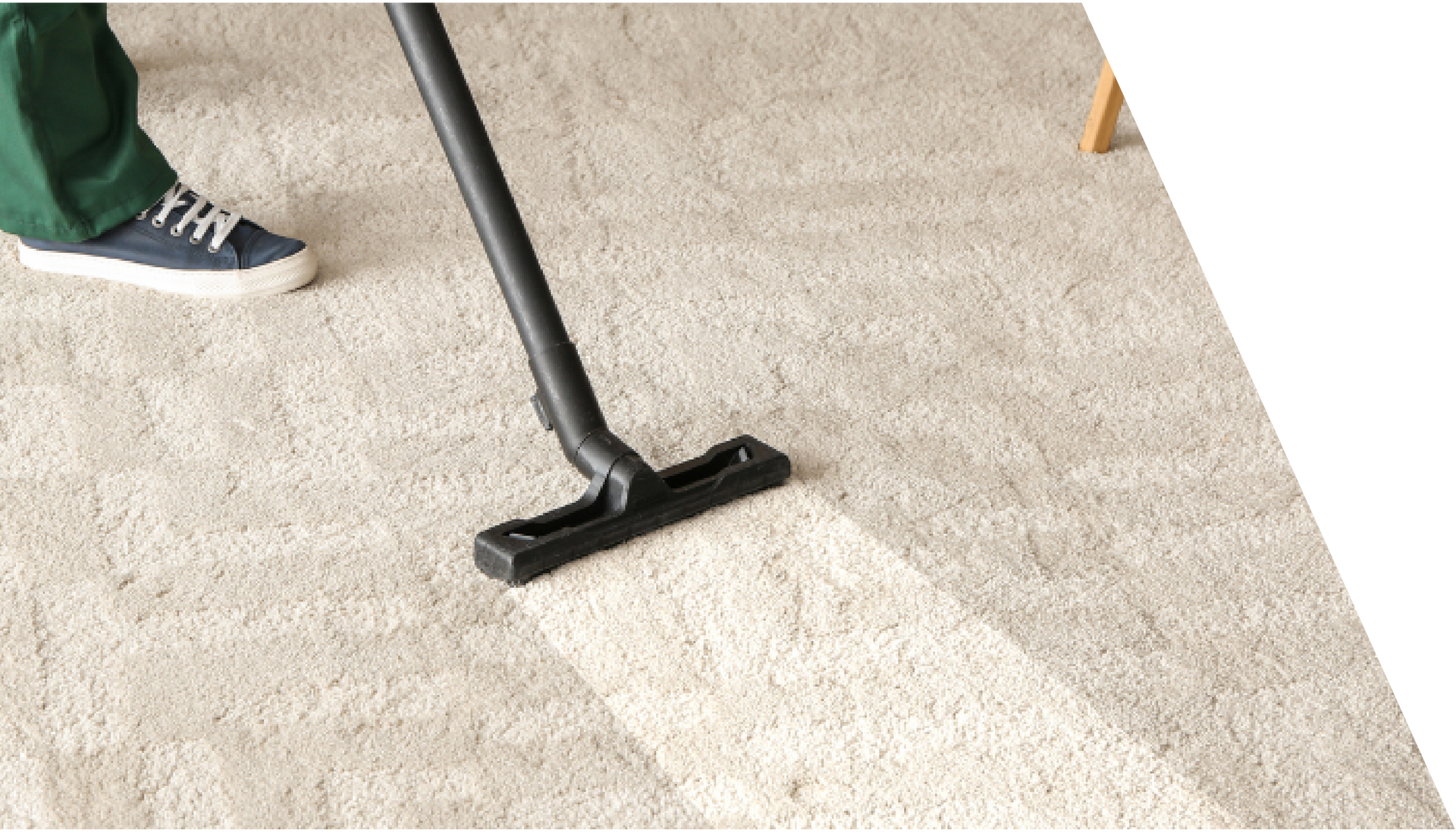 A person is using a vacuum cleaner to clean a carpet.