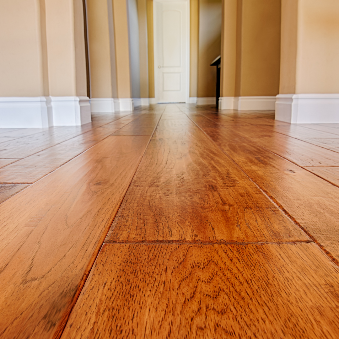 A hallway with hardwood floors and white trim in a house.