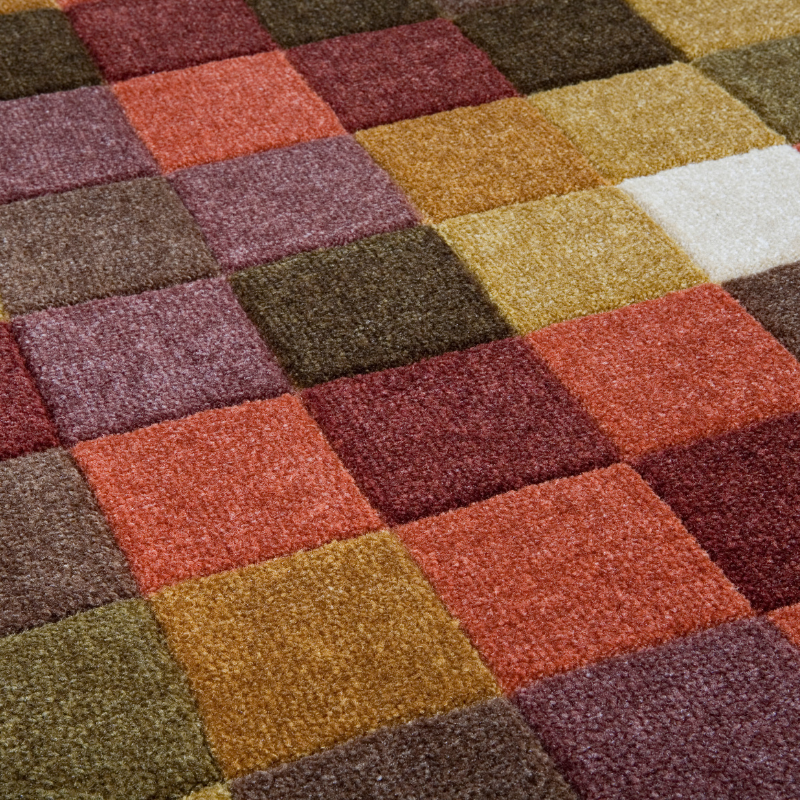 A close up of a colorful rug with squares of different colors