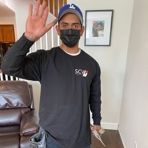 SCV Floorsmith team member standing in a living room, waving