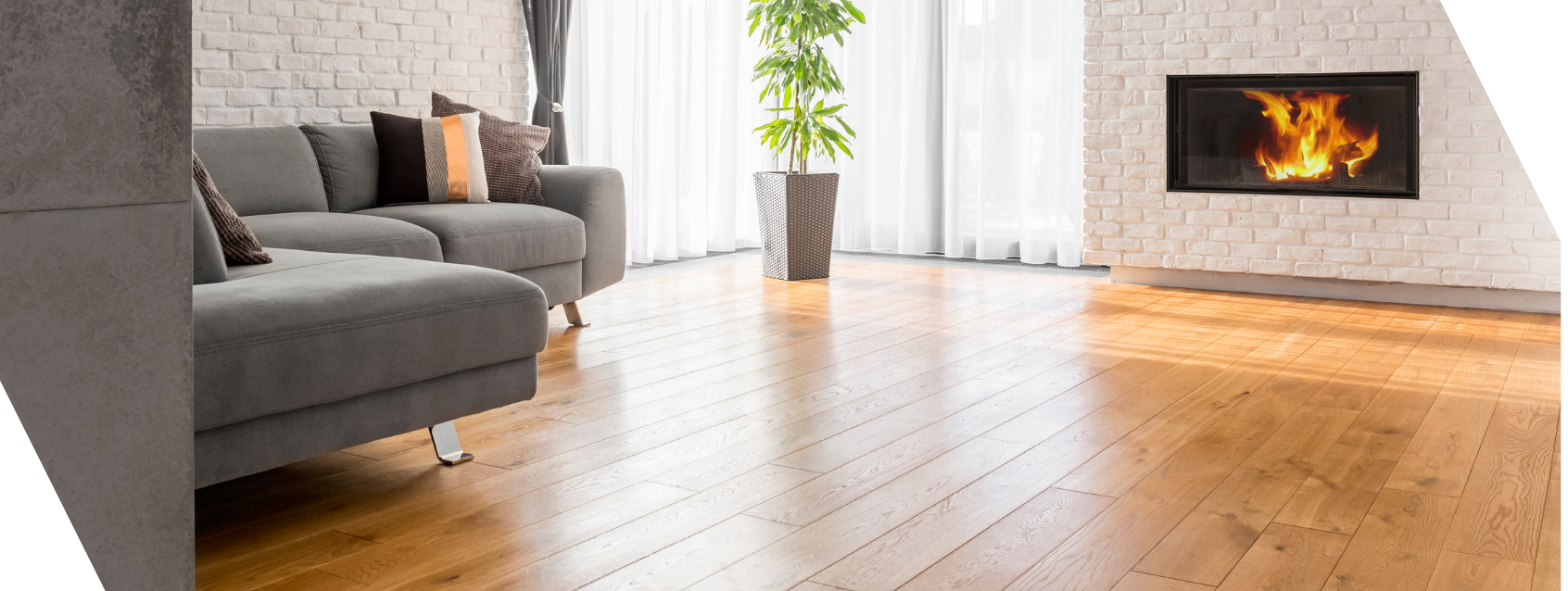 A living room with a couch , fireplace and wooden floor.