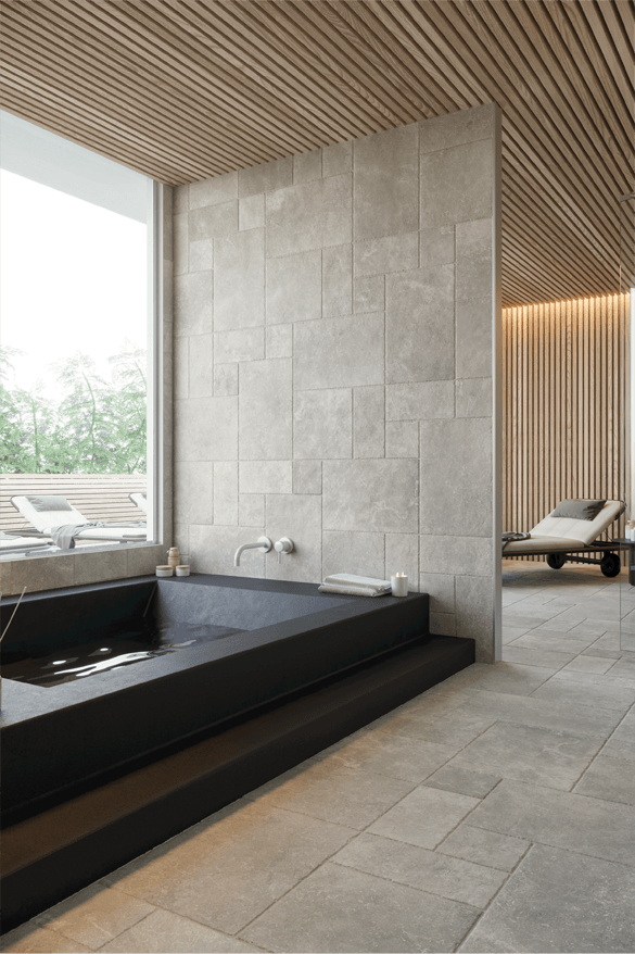 Natural stone texture tiles in a modern contemporary bathroom with a black tub