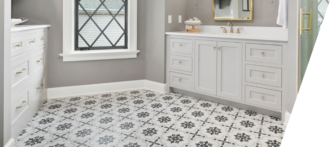 A bathroom with pattern tile flooring, sink , mirror , window and walk in shower.