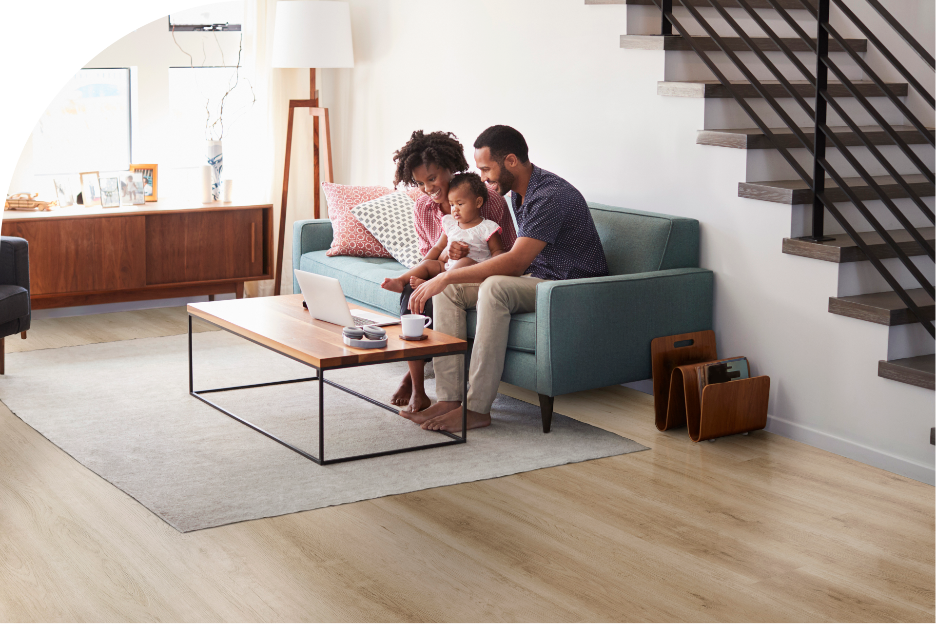 a happy family sitting on a couch in the living room with vinyl flooring