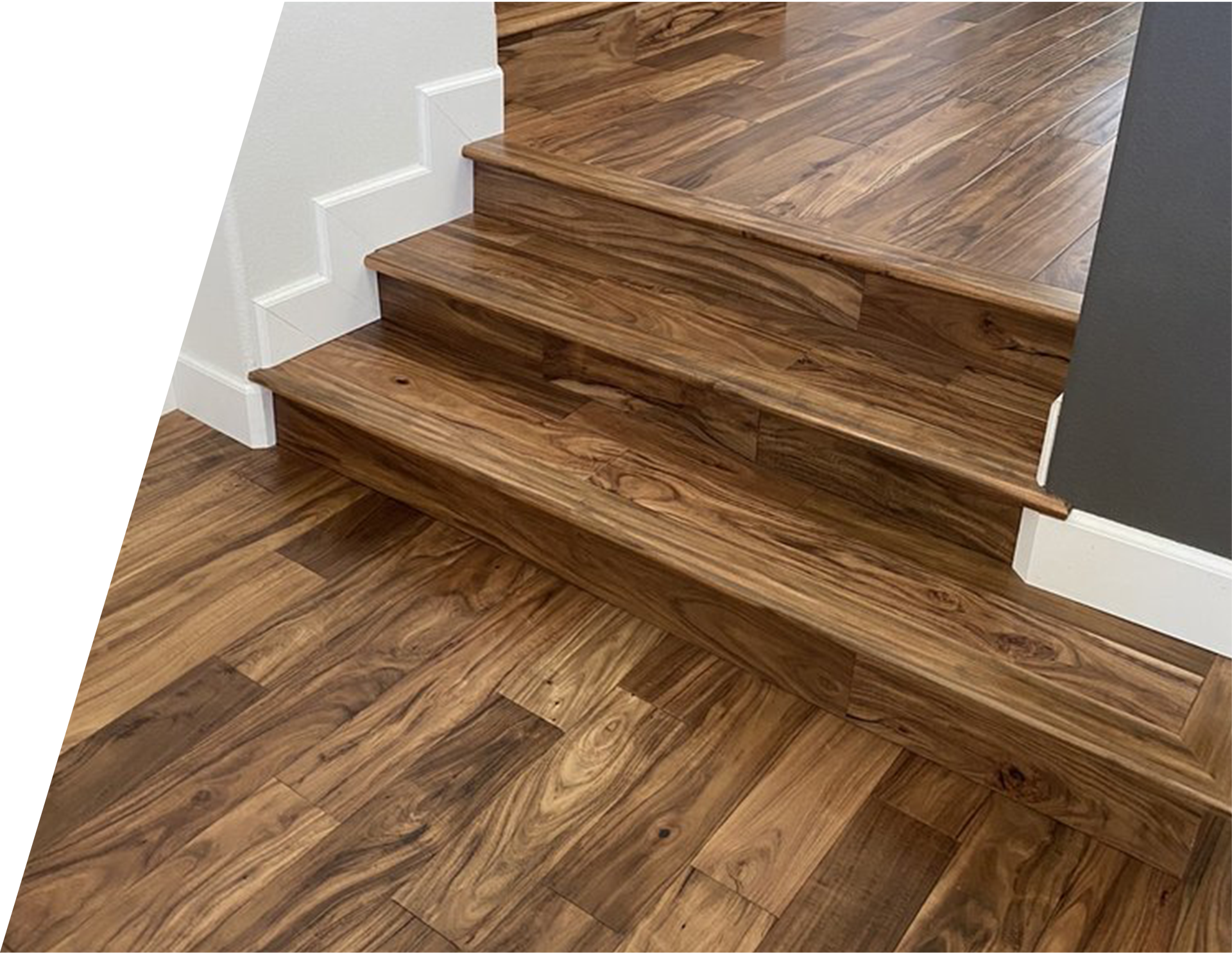 A close up of a wooden staircase with a wooden floor.