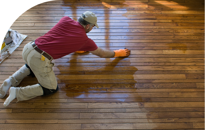 man refinishing a hardwood floor