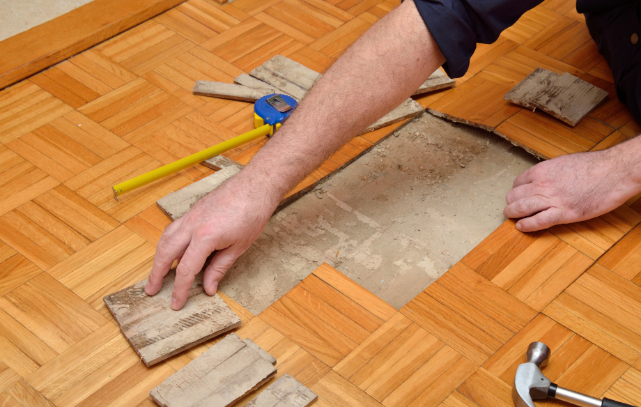 a man fixing square wooden floor tile