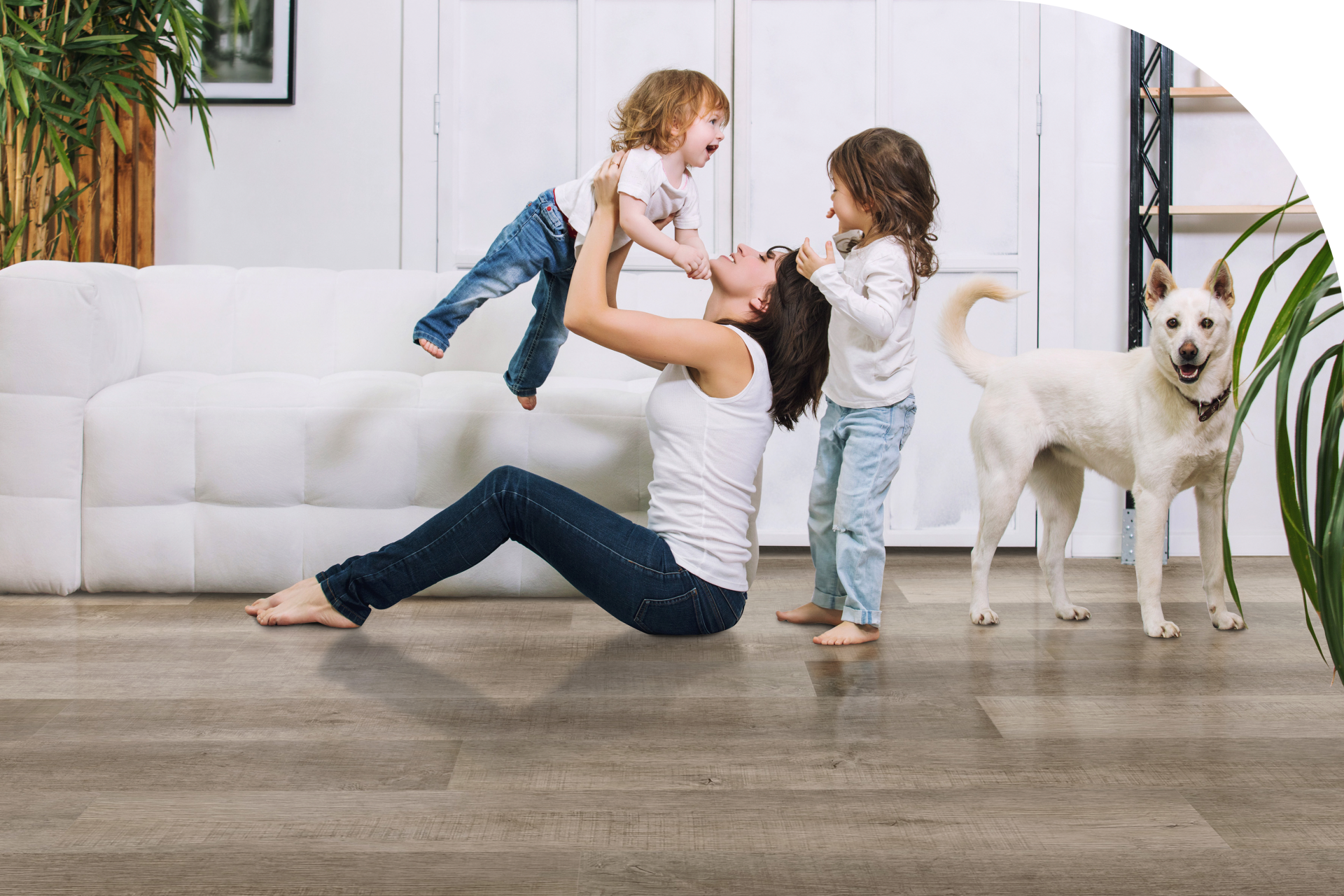 mother playing with her two daughters and a dog on a lvp flooring