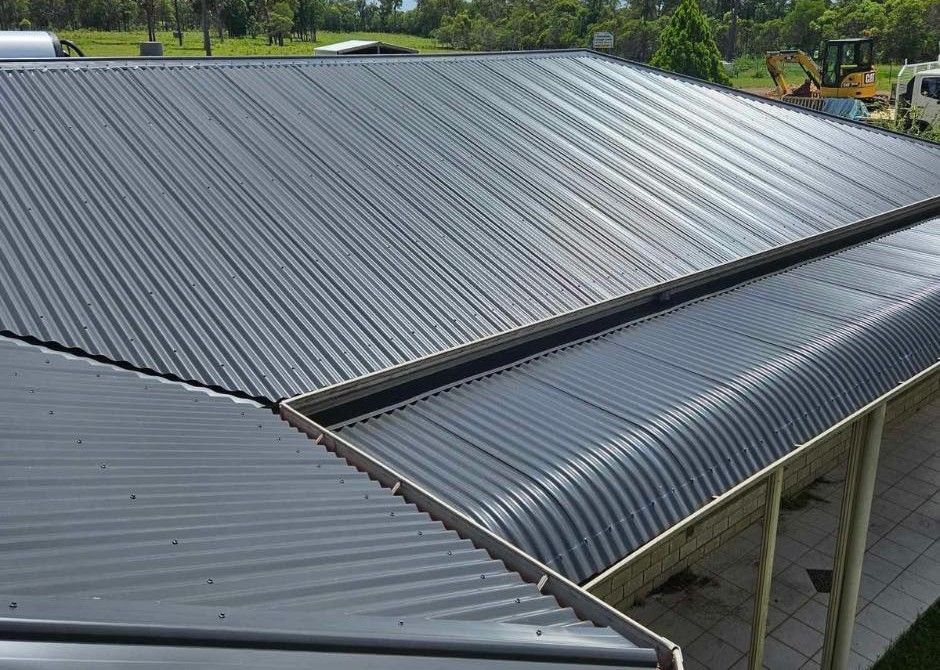 Gray Metal Roofs on a Building, With a Slight Curve on the Lower Edge, and Gutters — Venom Roofing Pty Ltd in Sunshine Coast, QLD