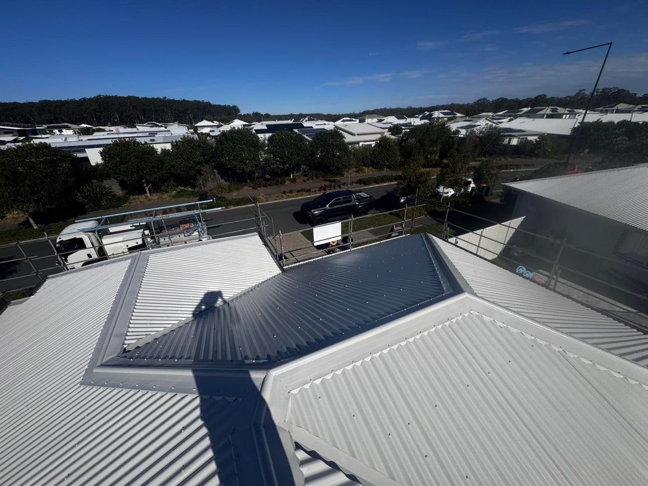 Overhead View of a Shiny, Corrugated Metal Roof With a Street — Venom Roofing Pty Ltd in Sunshine Coast, QLD