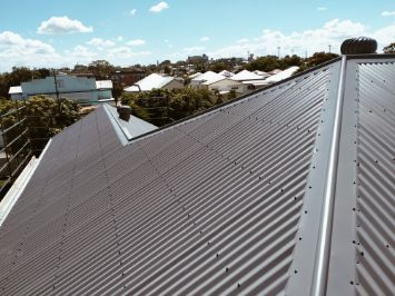 Gray Corrugated Metal Roof on a Residential Building With a Cityscape — Venom Roofing Pty Ltd in Sunshine Coast, QLD