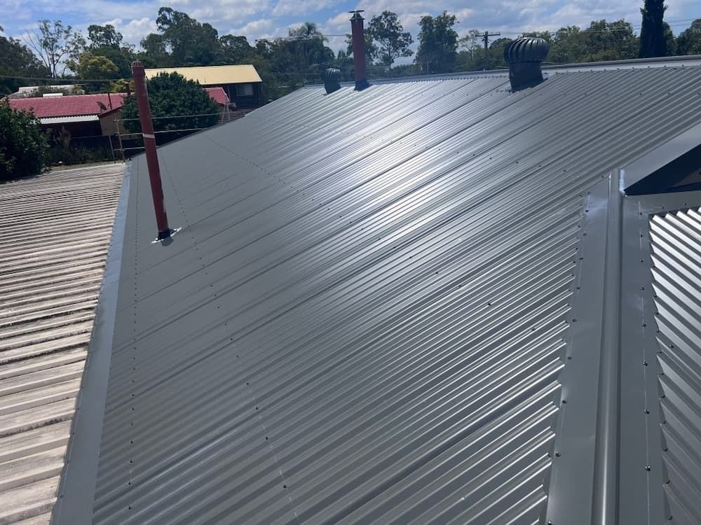 Gray Corrugated Metal Roof With Several Vents and Pipes — Venom Roofing Pty Ltd in Sunshine Coast, QLD