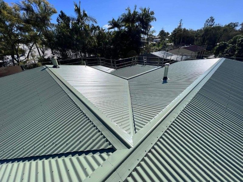 Green Corrugated Metal Roof With Safety Railing, Sunny Day — Venom Roofing Pty Ltd in Sunshine Coast, QLD
