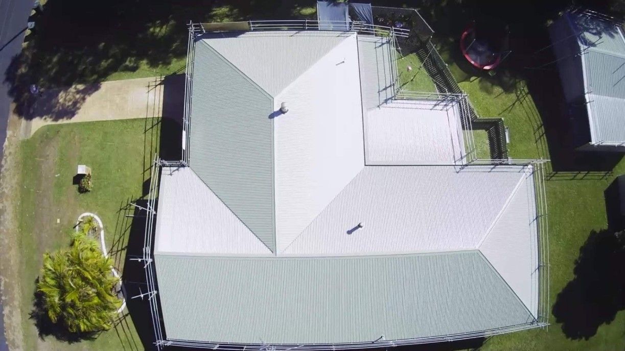 Overhead View of House With a Metal Roof, Surrounded by Green Grass and Trees — Venom Roofing Pty Ltd in Sunshine Coast, QLD