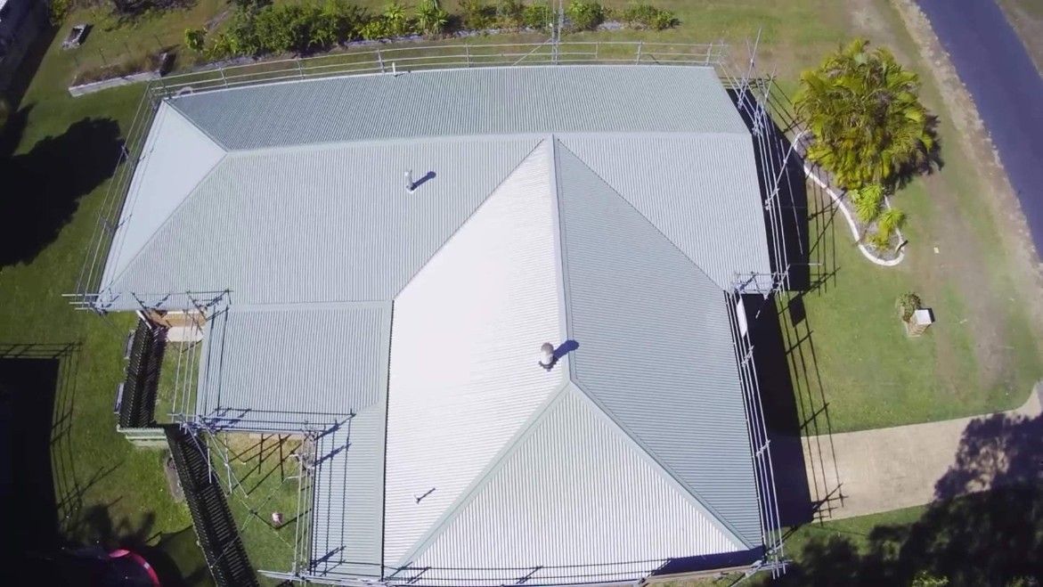 Aerial View of a Building With a Metal Roof Surrounded by Green Grass — Venom Roofing Pty Ltd in Sunshine Coast, QLD