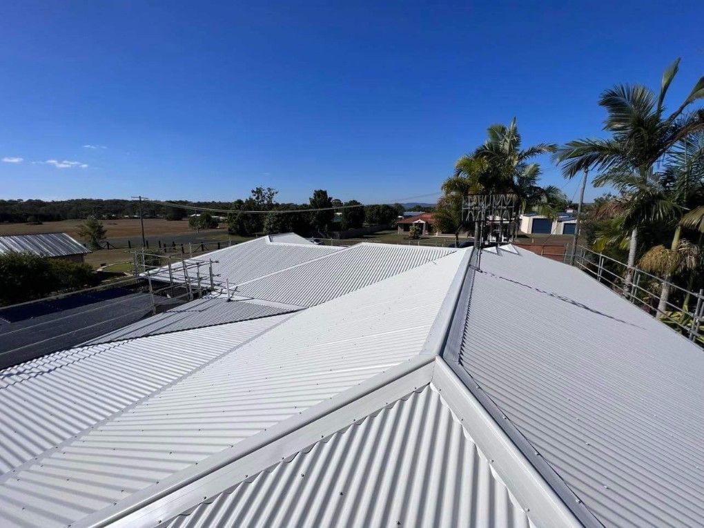 White Corrugated Metal Roof on a Sunny Day, With a Clear Blue Sky — Venom Roofing Pty Ltd in Sunshine Coast, QLD
