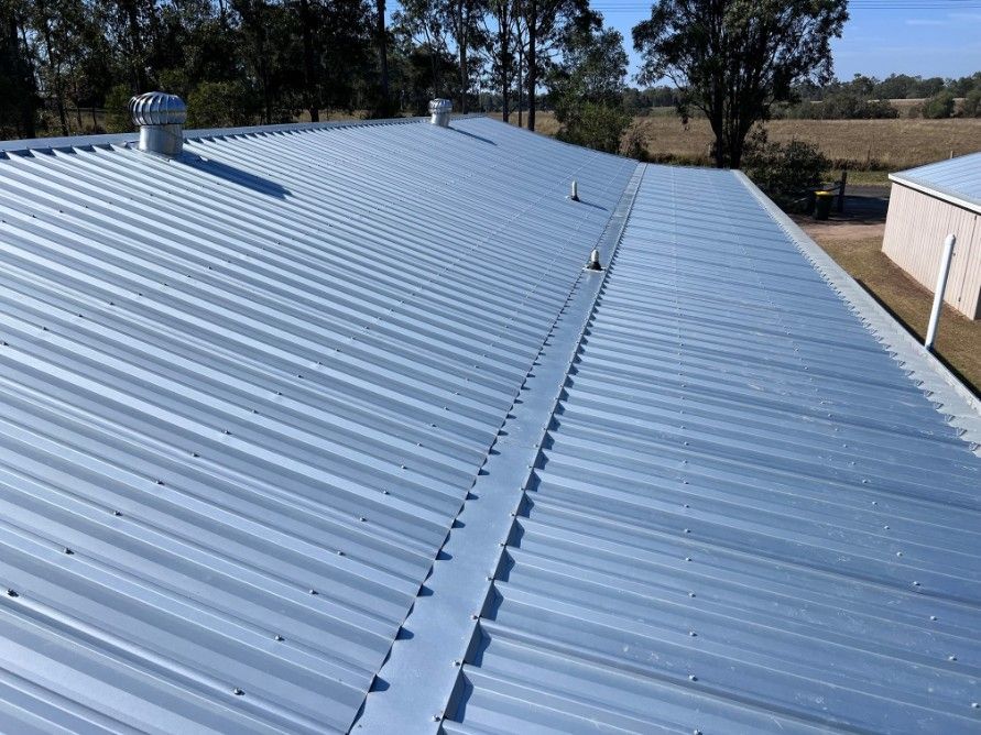 a Corrugated Metal Roof in a Field Under a Blue Sky — Venom Roofing Pty Ltd in Sunshine Coast, QLD