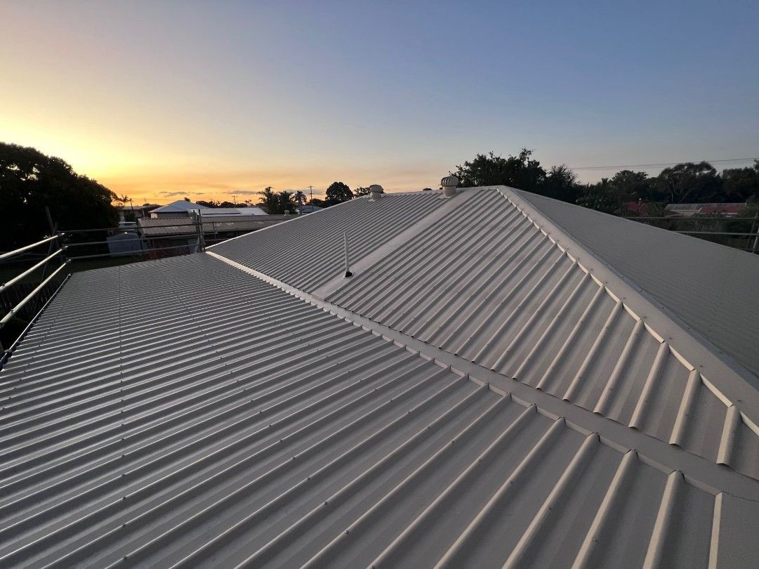 White Corrugated Metal Roof With a Sunset in the Background — Venom Roofing Pty Ltd in Sunshine Coast, QLD