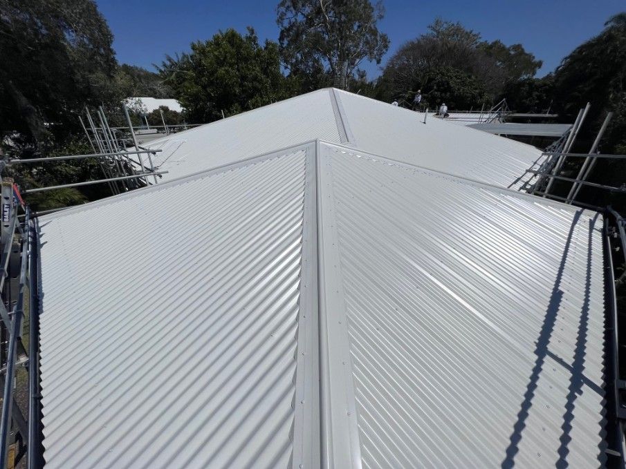 White Corrugated Metal Roof With Scaffolding, Surrounded by Trees — Venom Roofing Pty Ltd in Sunshine Coast, QLD