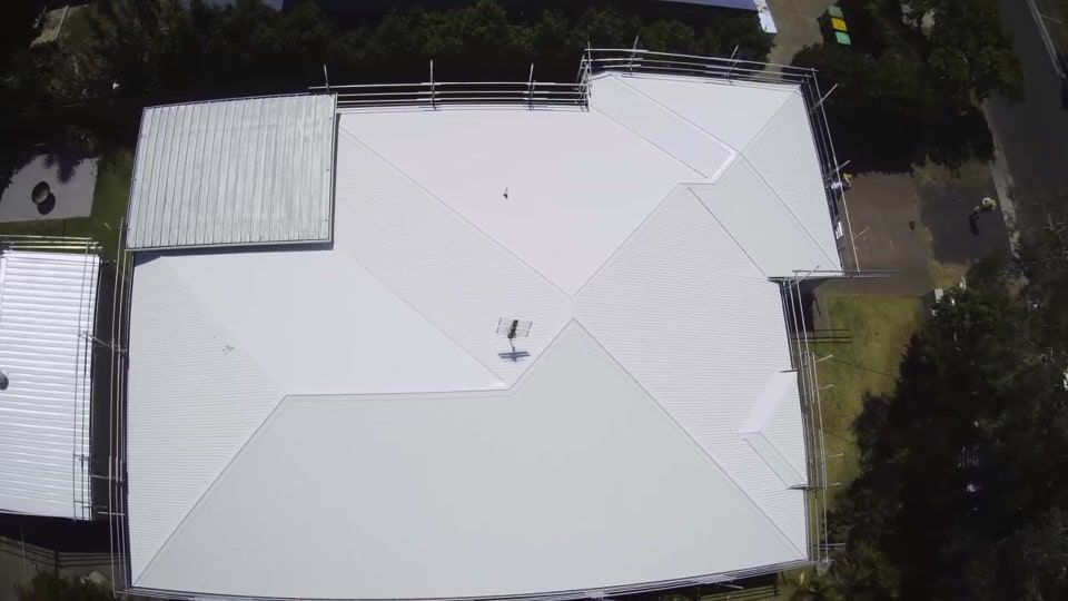 Overhead View of a White Metal Roof on a House, With Scaffolding Around Edges — Venom Roofing Pty Ltd in Sunshine Coast, QLD