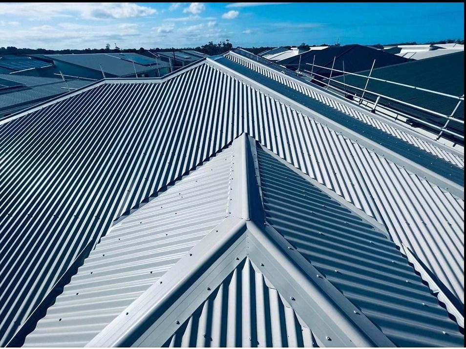 View of a Gray Corrugated Metal Roof With a Ridge and Clear Blue Sky — Venom Roofing Pty Ltd in Sunshine Coast, QLD