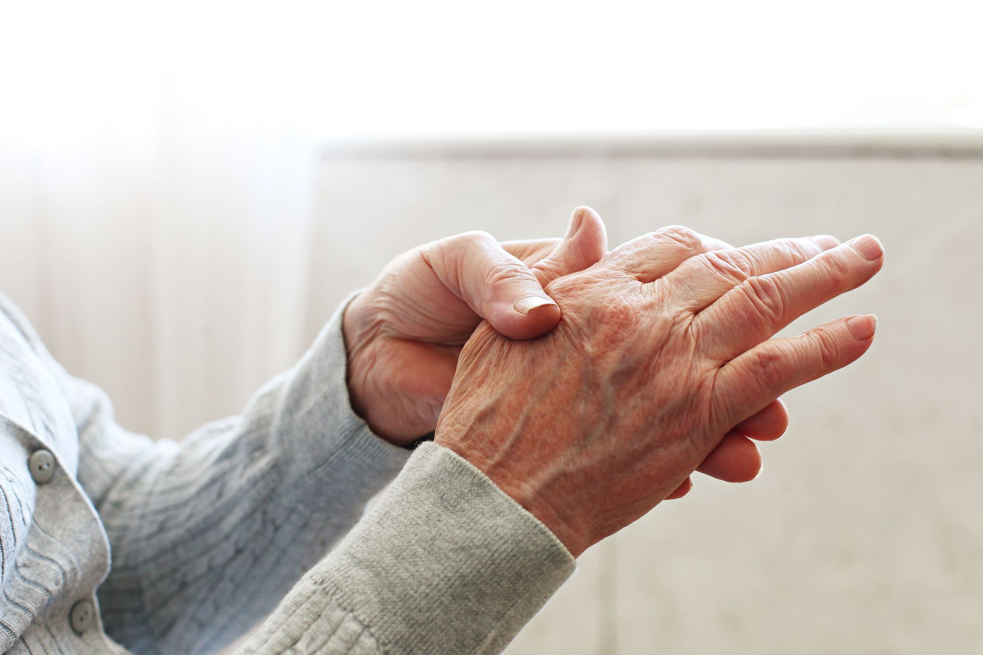 A woman is holding the hand of an older woman.