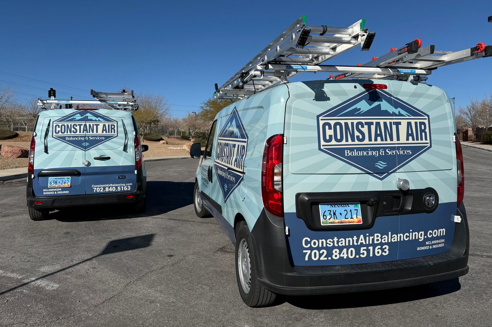 HVAC technician working on an air conditioning unit on a rooftop using a drill.