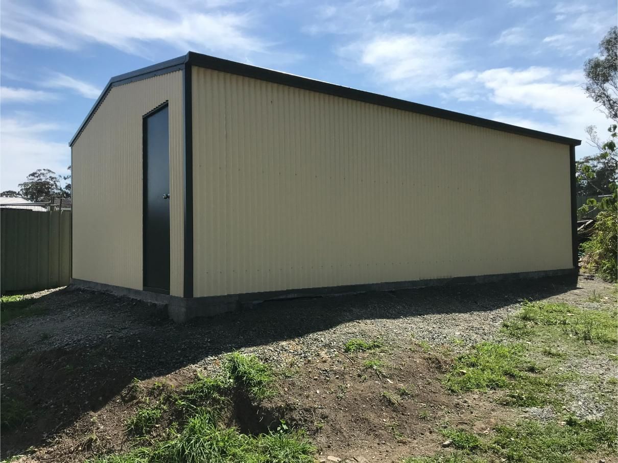 Tan Metal Shed With a Black Door — Bridgey's Constructions in Harrington, NSW