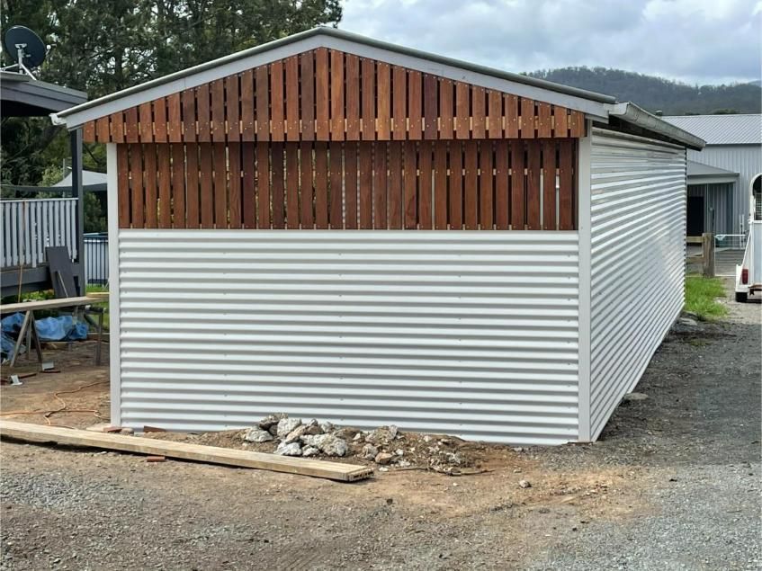A Light Grey Corrugated Metal Shed With a Brown Wooden Upper Facade — Bridgey's Constructions in Old Bar, NSW