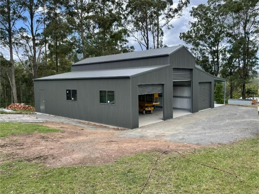 Grey Metal Barn-Style Building With Multiple Garage Doors — Bridgey's Constructions in Nabiac, NSW