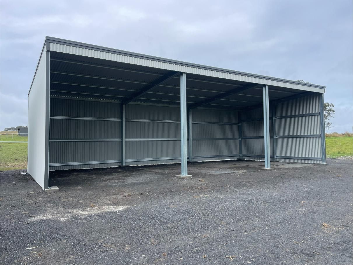Grey Metal Shed on a Gravel Surface Under a Cloudy Sky — Bridgey's Constructions in Pacific Palms, NSW